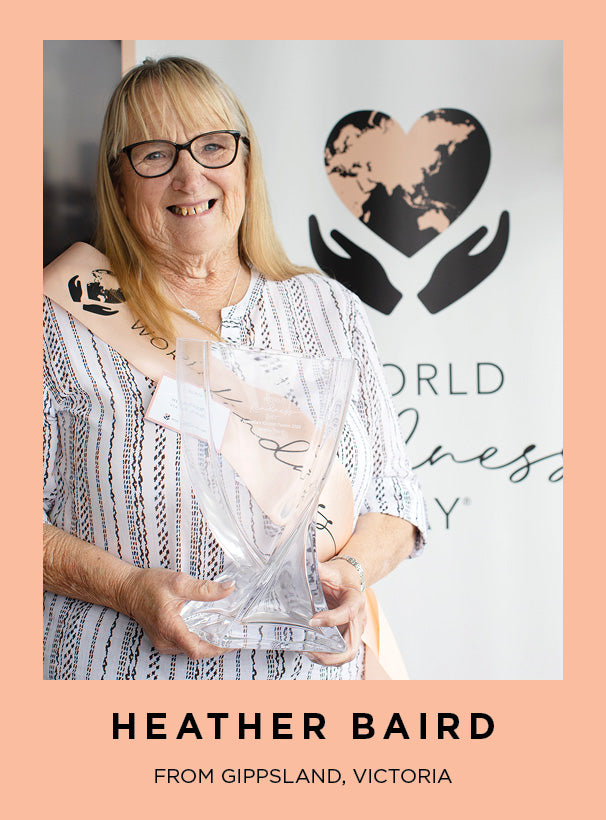 Heather Baird the World Kindness Day 2024 winner holding a clear throphy, with 