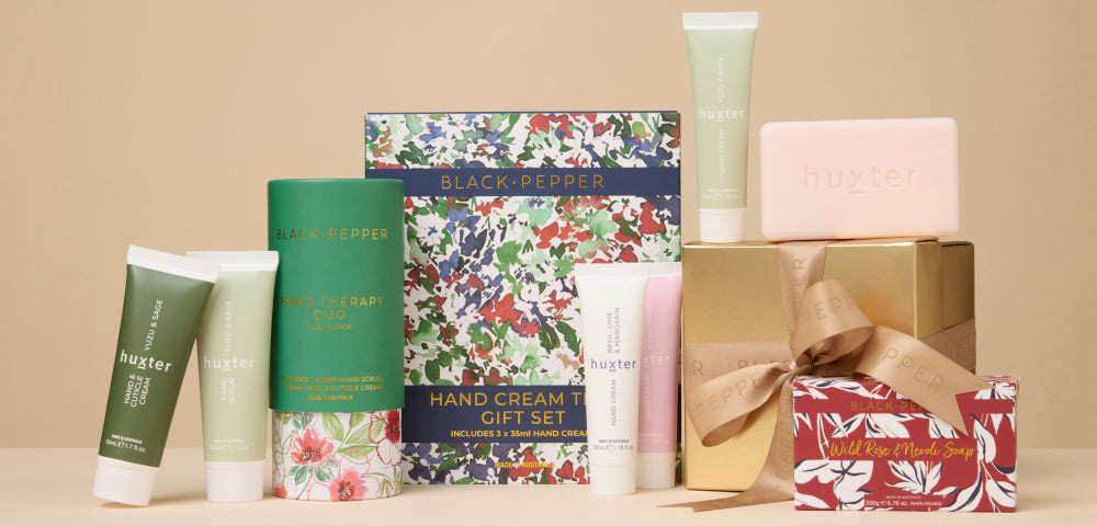 Collection of gift sets including hand cream, soap, and gift sets on a beige background